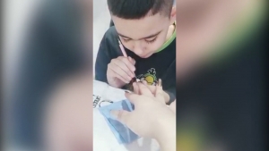 Video Niño de 9 años trabaja poniendo uñas de acrílico para ayudar a su hermanito con cirugía